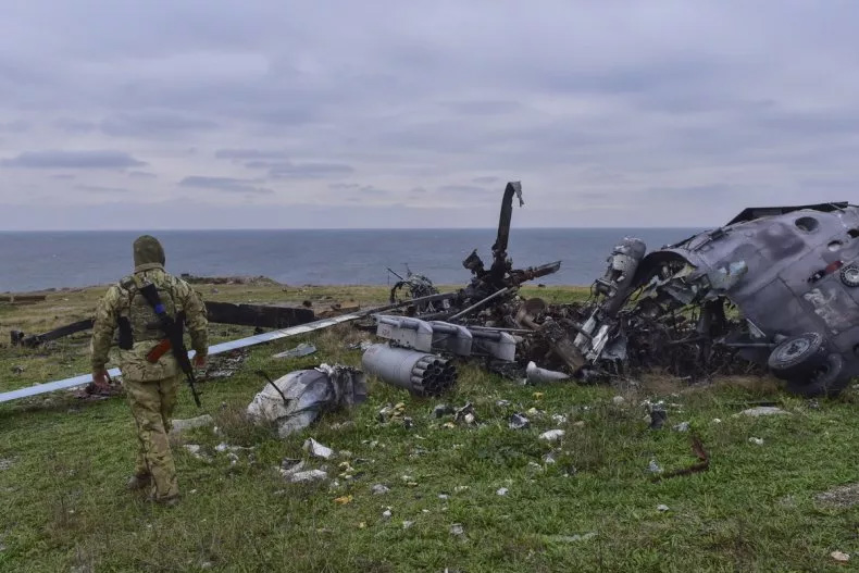 Ukrainian soldier examines a Russian helicopter on Snake Island